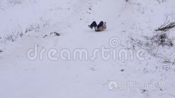 孩子们在冬天的公园里滑过雪橇，笑了起来。 慢动作。 快乐的女孩从山上滑下雪。