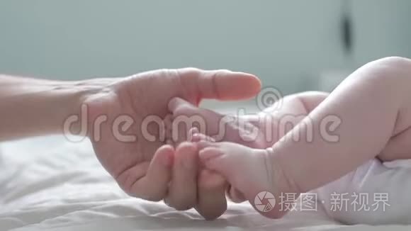 父亲抚摸并数着他的新生儿`小脚趾。 关上门。 父母抱着新生儿的脚。 快乐的父母。