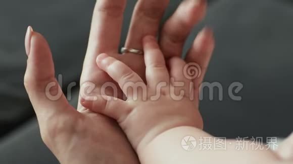 家长牵着婴儿的手。 新生儿与母亲携手