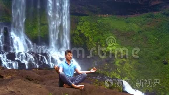 年轻人在瀑布中做呼吸瑜伽视频