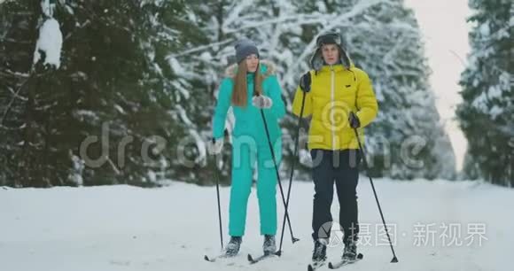 一对已婚夫妇正在森林里滑雪，练习健康的生活方式。 慢动作