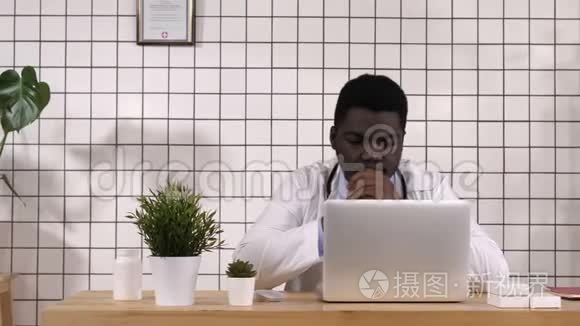 非裔美国医生在电脑和笔记本电脑上工作，读一些东西。