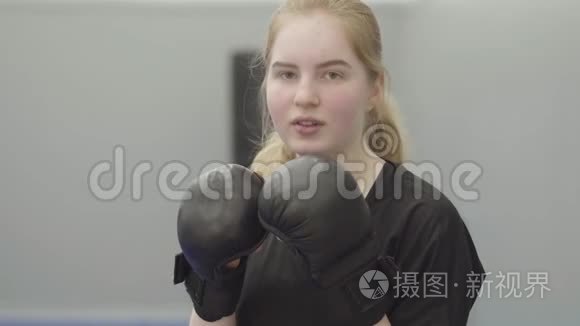 一位戴着拳击手套的年轻女子在镜头前