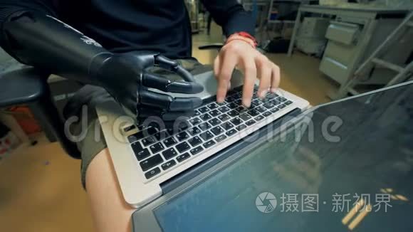 一个机器人手在膝上电脑上的工人。 4K.