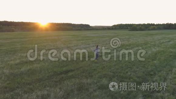 日落时分，女人走在田野上，手臂伸向两边。