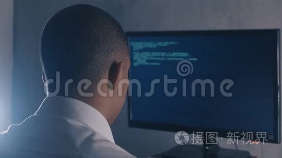 夜间办公室电脑显示器上程序员专业编程代码的背面视图