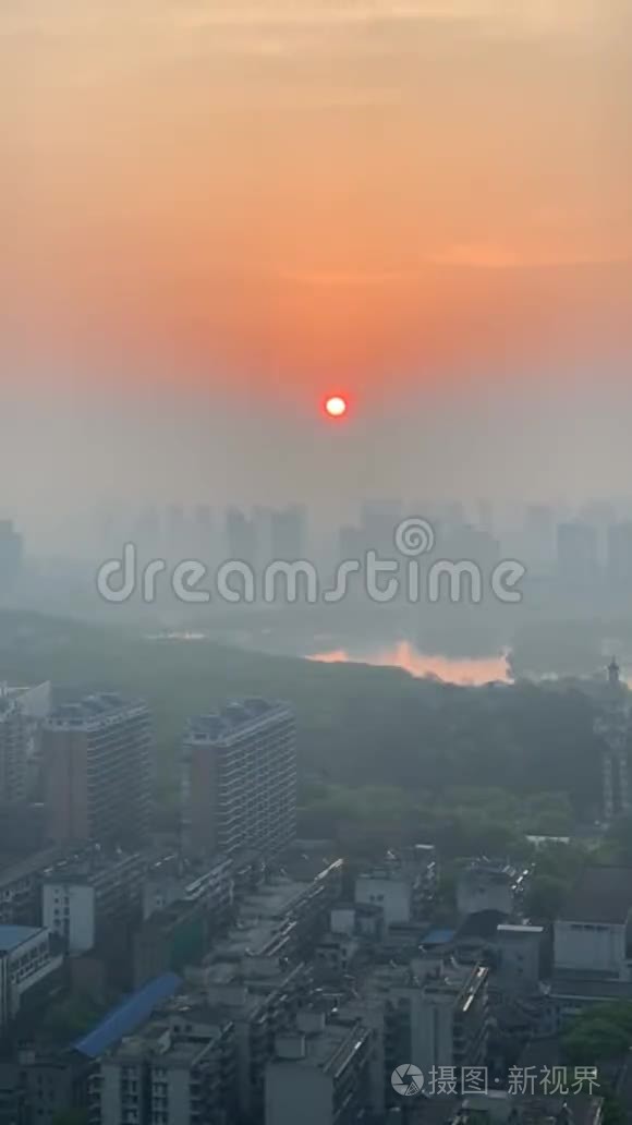 长沙的日出在烟雾和建筑物后面