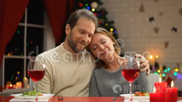 温柔的情侣拥抱，圣诞装饰闪闪发光，幸福的家庭肖像