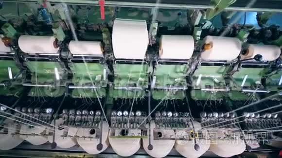 在纺织厂，白色纤维卷在大线轴上。