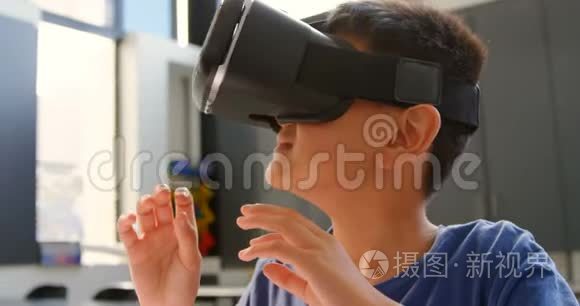 亚洲小学生坐在课桌前，4k教室使用虚拟现实耳机