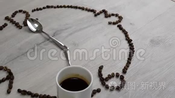 该喝咖啡了。 咖啡豆的表盘放在木桌上. 一杯咖啡，而不是7点钟和勺子