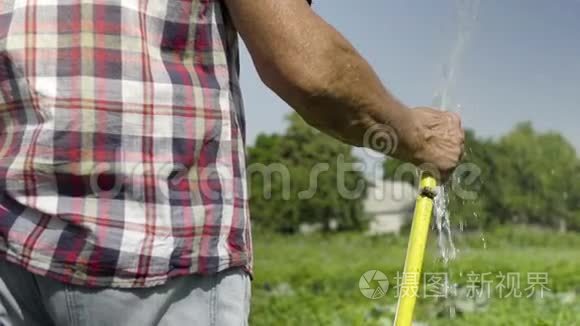 园丁用水管缓慢地浇灌绿色草地视频