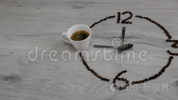 该喝咖啡了。 咖啡豆的表盘放在木桌上. 一杯咖啡，而不是9点`钟和勺子
