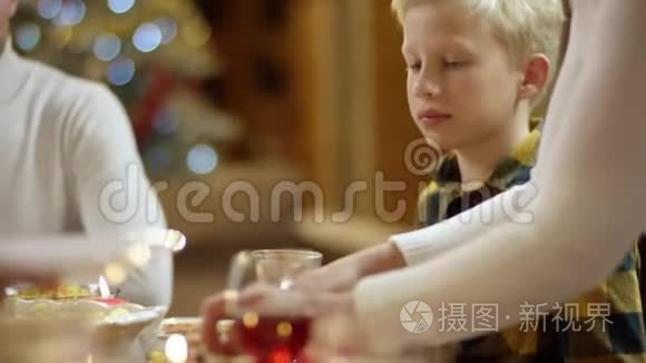 成年白种人妇女在圣诞餐桌上给儿子放馅饼
