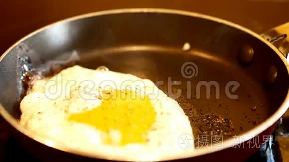 新鲜的鸡蛋和磨尖的胡椒在热炒锅里炒，蒸汽上升