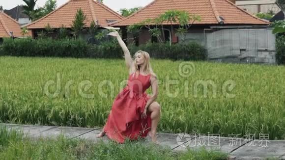 一个体格健壮的女孩穿着一件红色的长裙，在现代舞蹈中，她想出了一个舞蹈动作