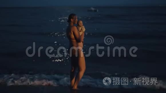 妈妈带着宝宝在晚上享受海风