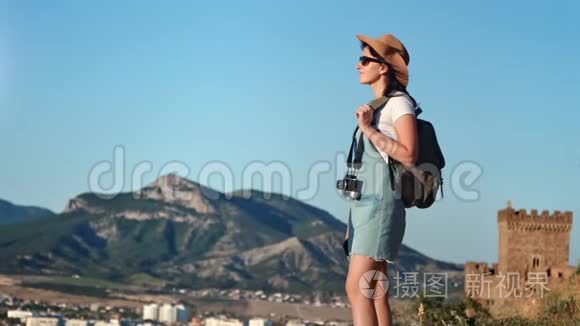 活动背包旅行的女人站在山顶欣赏令人惊叹的风景