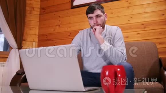 一个困惑的人坐在笔记本电脑旁视频