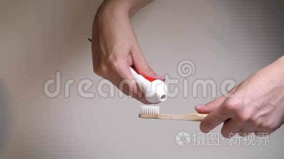白色的刷毛与新鲜的黑色牙膏。 把牙膏从管子里挤到木制牙刷上。