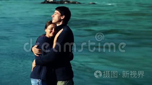 两个情人在蓝水的背景下拥抱视频