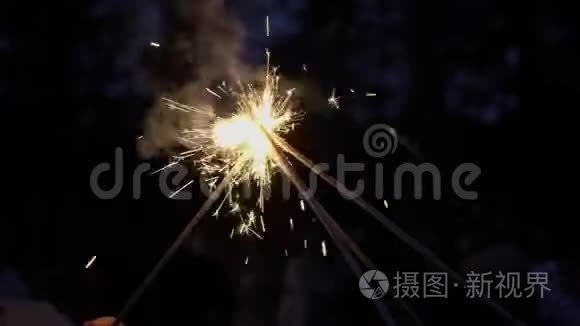 人们在街上点燃火花。 庆祝新年、圣诞节或其他节日。 浪漫的夜晚或夜晚