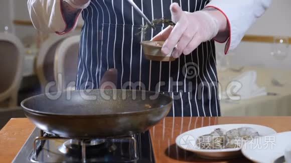 出去吃饭。 准备食物。 厨师把药草和大蒜放到煎锅里。 沸腾的油溅。 慢慢