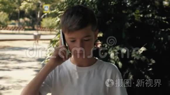 夏天，一个十几岁的男孩在公园里用智能手机聊天。