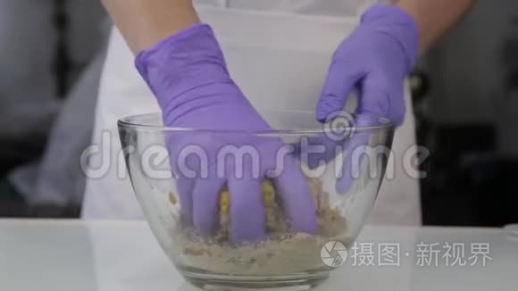 糖果师把糖果的原料混合在玻璃碗里。 手工制作的糖果