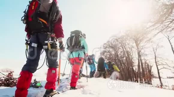 装备登山者互相跟随穿越高雪，视线从后..