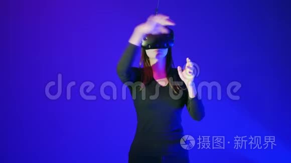 漂亮的年轻女孩使用现代VR眼镜。 女人触摸一些东西，翻转，推动，增加使用现代虚拟