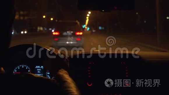 手放在汽车的方向盘上。 夜间驾驶POV