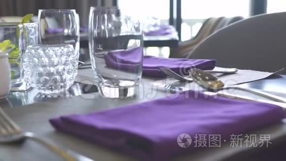 餐桌设置餐厅概念.. 把棉布餐巾、眼镜、勺子、叉子和刀子都贴在餐桌上