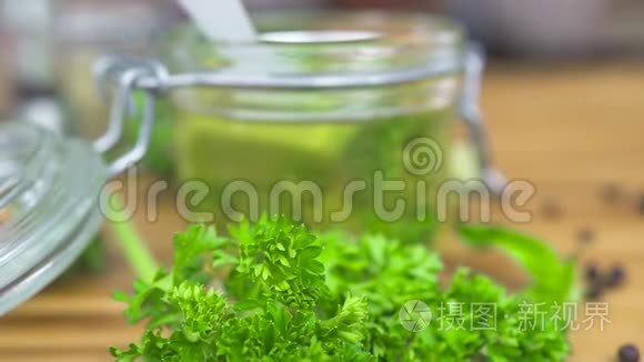玻璃罐中的橄榄油，用于木制桌子上烹饪的草药。 希腊菜用的圣母橄榄油。 调味料和香料