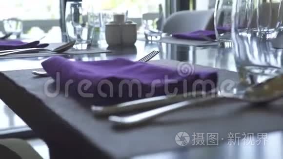 餐桌设置餐厅概念.. 把棉布餐巾、眼镜、勺子、叉子和刀子都贴在餐桌上