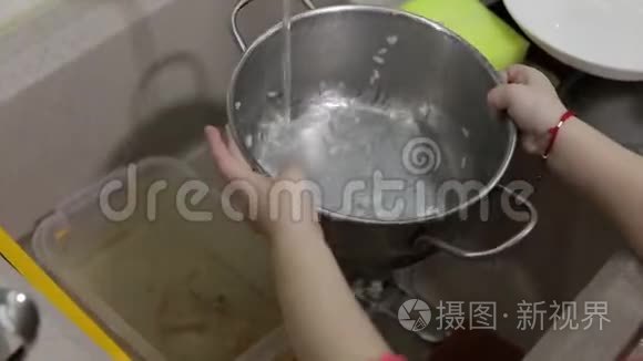 孩子在厨房洗碗。 双手合拢