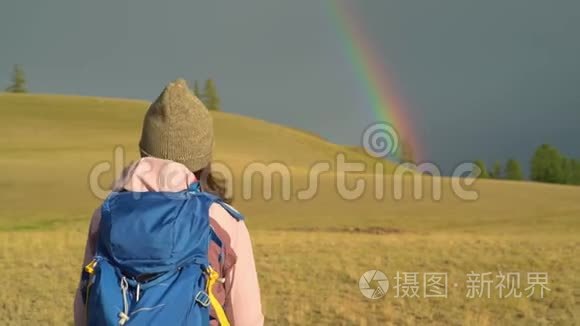 女人徒步旅行。 在山上远足。 带背包的女旅行者在美丽的夏季景观上。 一个女孩走进来