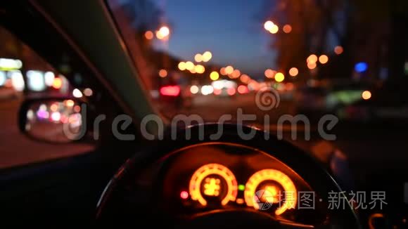 晚上开车。 侧后视镜从车上看.. 模糊的城市灯光。 4k