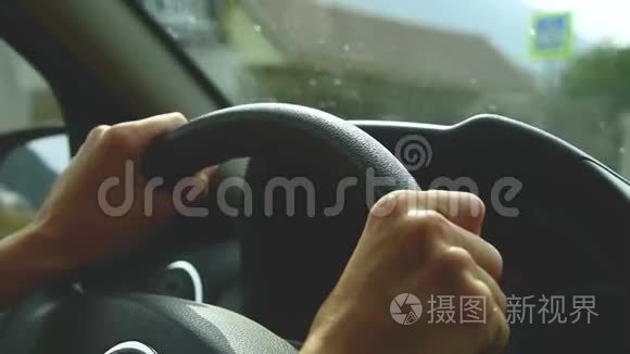 打开光圈的特写。 那个女孩在乡间小路上开车。 女人`把手放在方向盘上