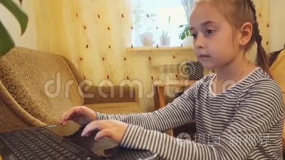 一个小女孩用笔记本电脑工作或玩它。
