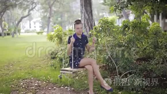 在公园里，一个年轻的女孩骑着一个木秋千