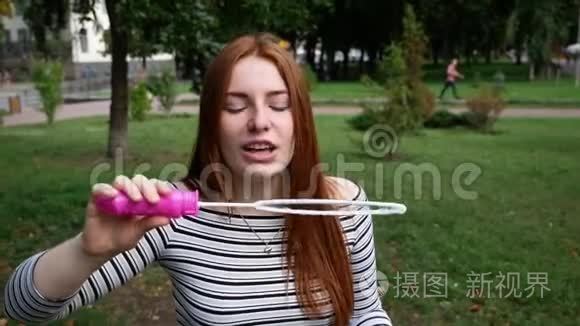 红发女孩在公园里吹肥皂泡视频