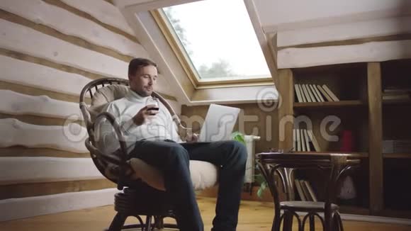 成年男子在椅子上用电脑喝酒mov4K视频素材