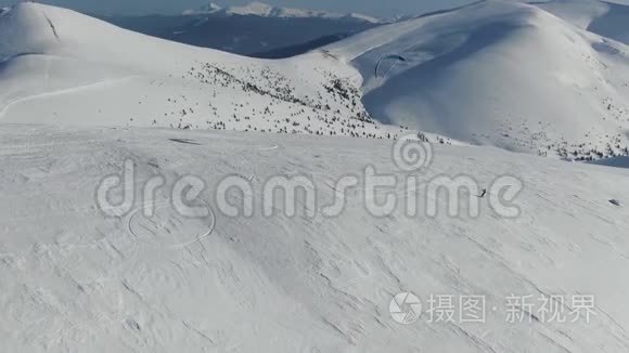 一个人在山上的斜坡上快速滑行，令人惊叹的雪山景色，空中射击