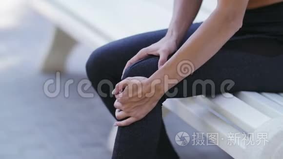 接近女运动员跑步者在疼痛中触摸膝盖，健身妇女在夏季公园跑步。