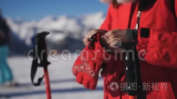 女滑雪者戴着手套和滑雪护目镜，拿起他的滑雪杆，开始下山。