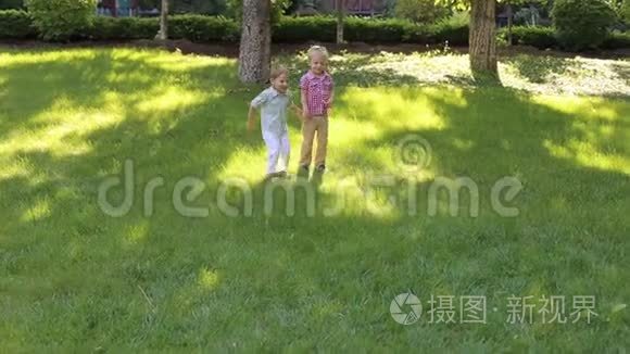 日落时分，两个小男孩在公园的草地上奔跑。