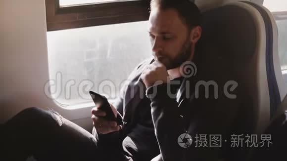 自信严肃的高加索商人在智能手机移动办公应用程序上发短信，坐在现代火车窗口座位上。