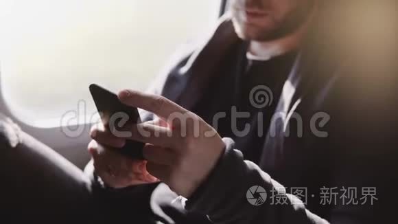 近距离观看快乐轻松的欧洲男人在智能手机信使应用程序上输入信息，在火车窗口座位上旅行。