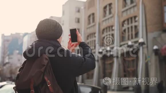 城市街头的男子游客拍摄建筑物视频